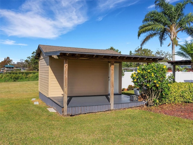 view of side of home with an outdoor structure and a yard