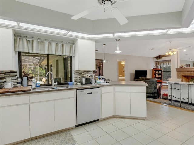 kitchen with backsplash, dishwasher, white cabinetry, and sink