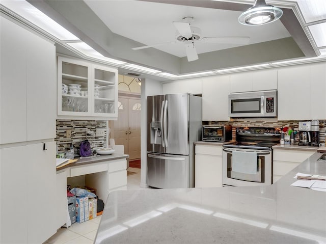 kitchen featuring white cabinets, backsplash, stainless steel appliances, and ceiling fan