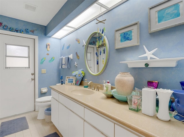 bathroom with tile patterned flooring, vanity, and toilet