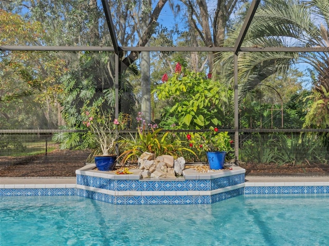 view of swimming pool featuring a fenced in pool and glass enclosure