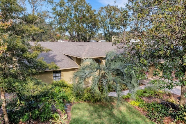 view of front of house with a shingled roof and stucco siding