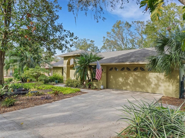 view of front of home with an attached garage, concrete driveway, and stucco siding