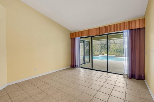 spare room with lofted ceiling, baseboards, and light tile patterned flooring