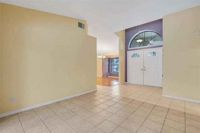 foyer featuring light tile patterned floors, visible vents, baseboards, and an inviting chandelier