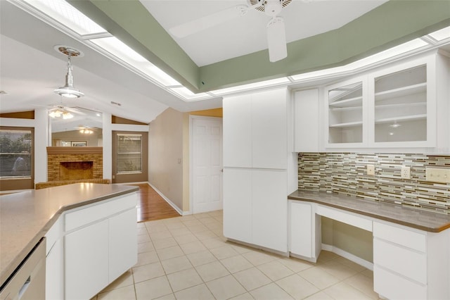 kitchen with lofted ceiling, dishwashing machine, a ceiling fan, built in study area, and decorative backsplash