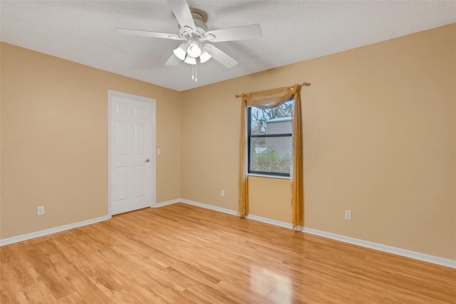 unfurnished room with light wood-type flooring, ceiling fan, baseboards, and a textured ceiling