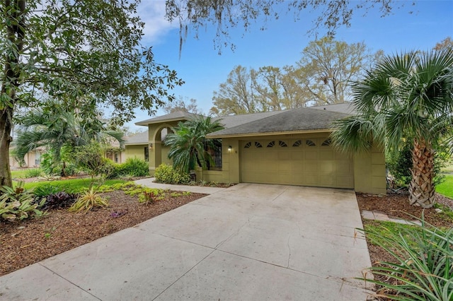 view of front of property with concrete driveway, an attached garage, and stucco siding