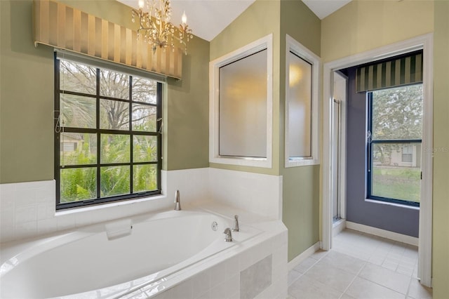 full bathroom with a wealth of natural light, a garden tub, and tile patterned floors