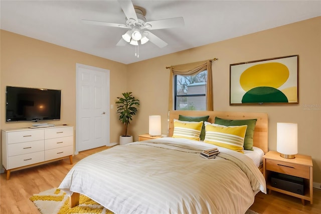 bedroom with light wood-style floors and a ceiling fan