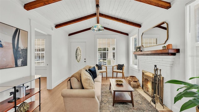 living room with lofted ceiling with beams, light hardwood / wood-style floors, wood ceiling, and a brick fireplace