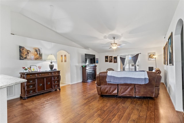 bedroom featuring a fireplace, hardwood / wood-style flooring, vaulted ceiling, and ceiling fan