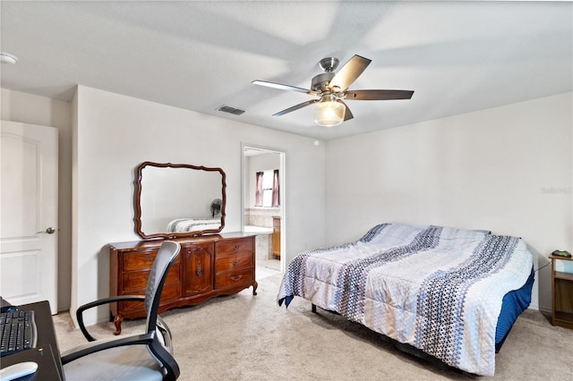 carpeted bedroom with ensuite bath and ceiling fan