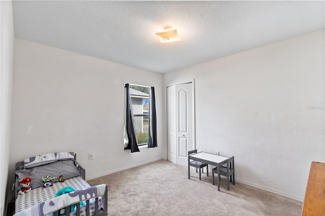 bedroom with light carpet and a textured ceiling