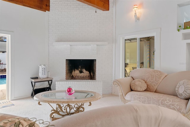 carpeted living room featuring a fireplace, a high ceiling, and beamed ceiling