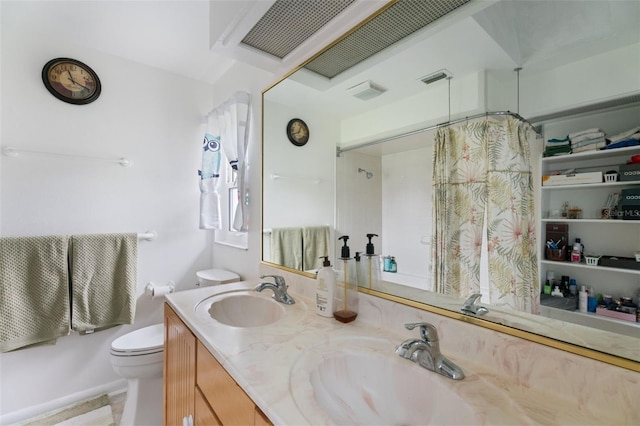 bathroom featuring double vanity, curtained shower, a sink, and toilet