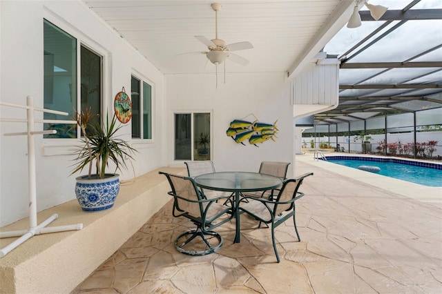 view of pool with ceiling fan, glass enclosure, outdoor dining area, a fenced in pool, and a patio area