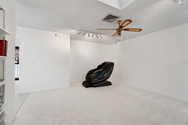 interior space featuring a ceiling fan, rail lighting, visible vents, and a textured ceiling