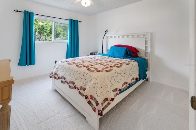 carpeted bedroom with ceiling fan, baseboards, and a textured ceiling