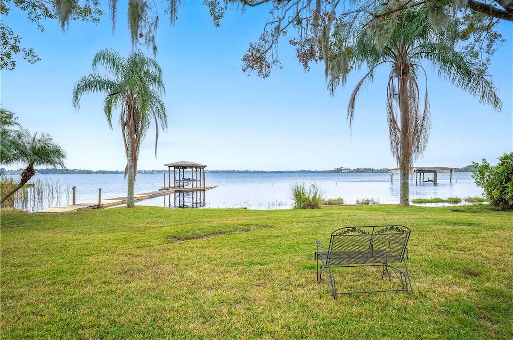 view of yard featuring a water view and a dock