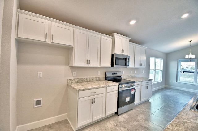 kitchen with white cabinetry, appliances with stainless steel finishes, vaulted ceiling, and pendant lighting