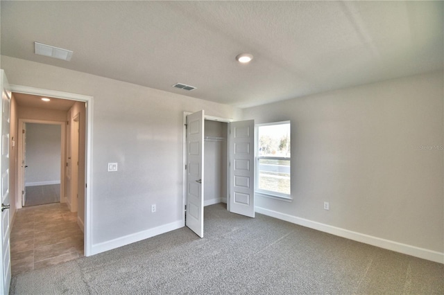 unfurnished bedroom featuring carpet flooring and a closet