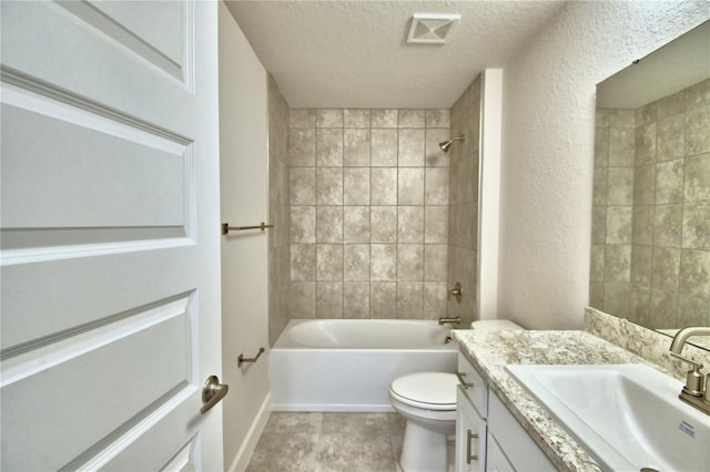 full bathroom featuring vanity, a textured ceiling, tile patterned floors, toilet, and tiled shower / bath