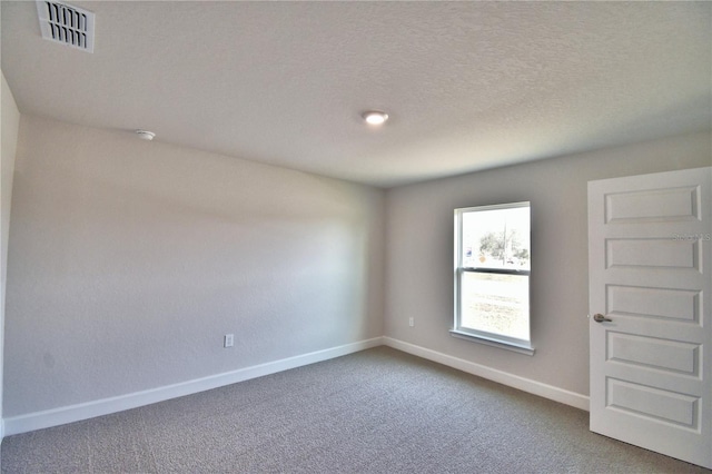 carpeted spare room with a textured ceiling