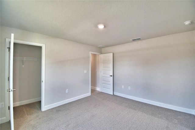 unfurnished bedroom featuring carpet floors, a closet, and a textured ceiling