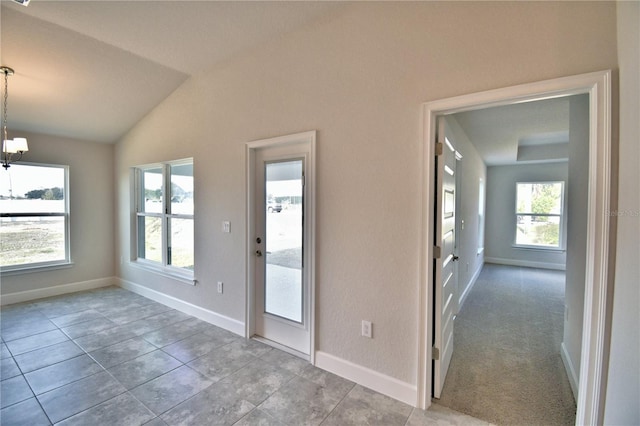 interior space featuring lofted ceiling, a notable chandelier, and light tile patterned flooring