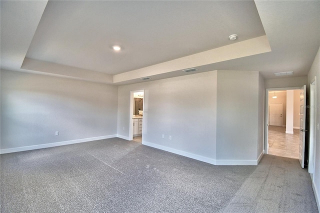 spare room with a raised ceiling and carpet floors