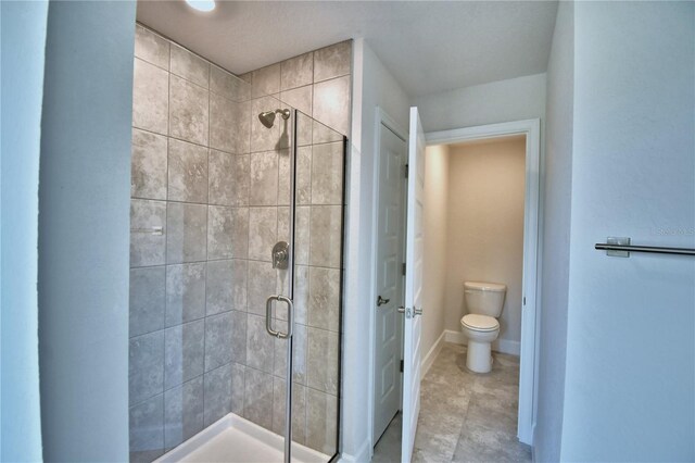 bathroom featuring toilet and a shower with door