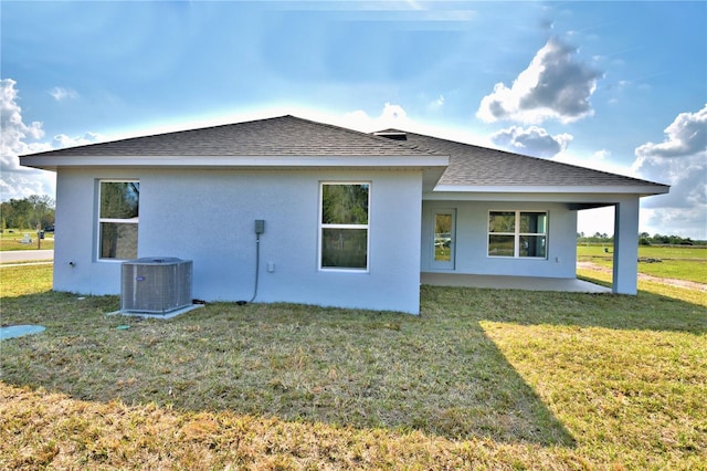 rear view of house with a lawn, a patio area, and central air condition unit