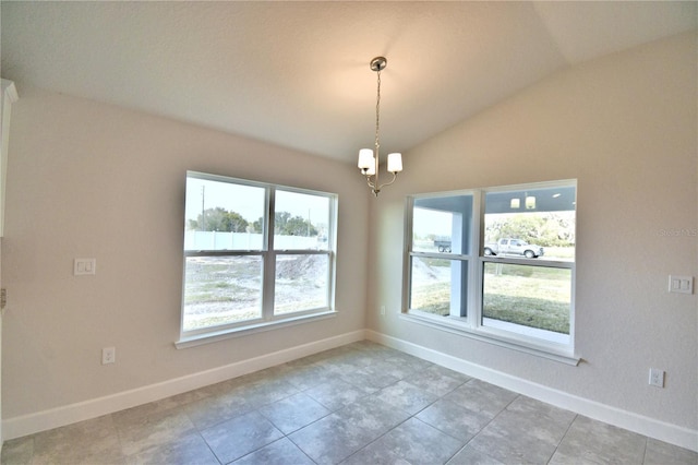 empty room with vaulted ceiling and a chandelier