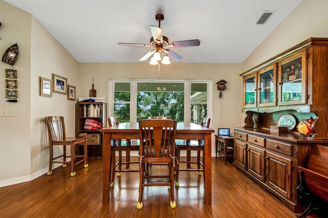 dining space with ceiling fan, dark hardwood / wood-style flooring, and vaulted ceiling