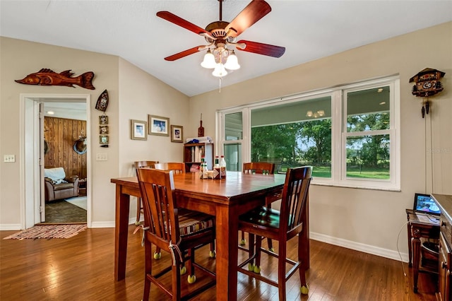 dining area with ceiling fan, lofted ceiling, and dark wood-type flooring