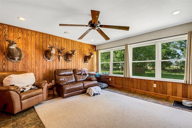 carpeted living room featuring a textured ceiling and wood walls