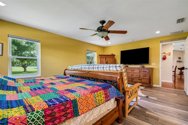 bedroom with ceiling fan and light hardwood / wood-style floors