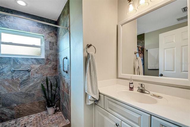 bathroom featuring tiled shower and vanity