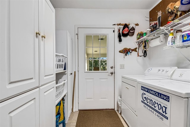 washroom with washer and dryer and cabinets