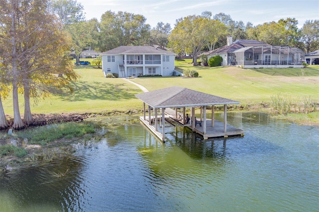 view of dock with a lawn and a water view