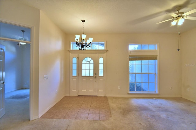 carpeted foyer entrance featuring ceiling fan with notable chandelier