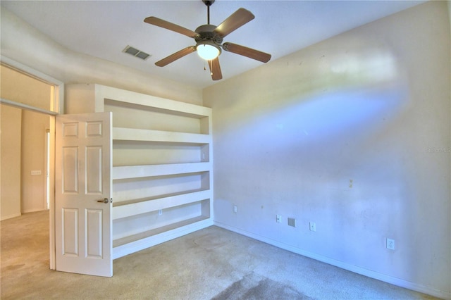 carpeted spare room featuring ceiling fan