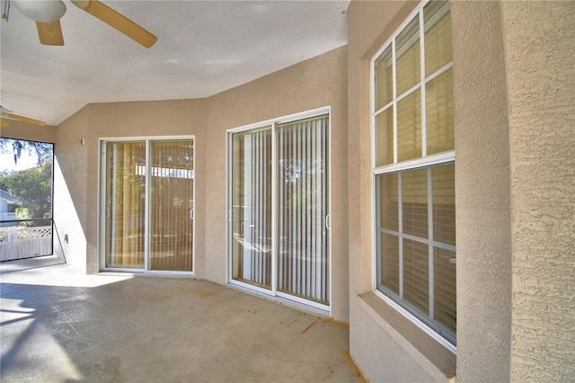 unfurnished sunroom featuring ceiling fan