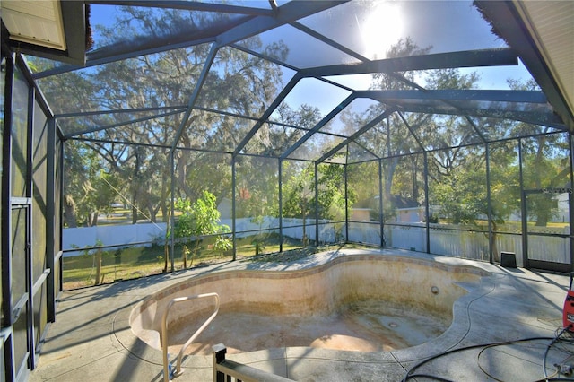 view of swimming pool with glass enclosure and a patio