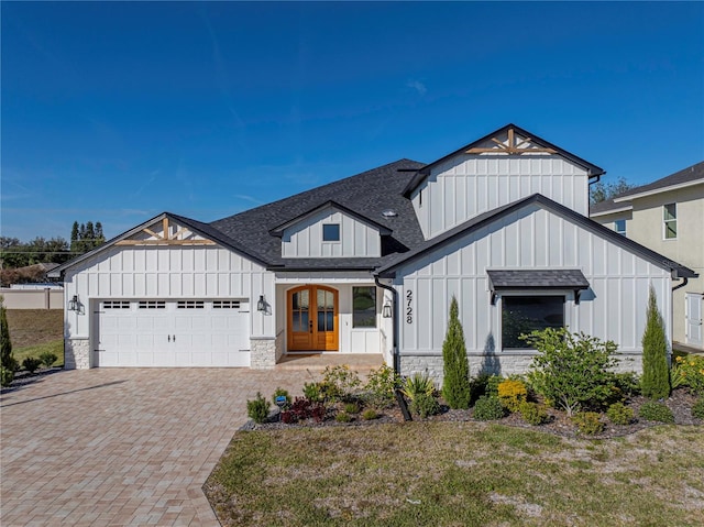 2728 Sunrise Landing Ln, Lakeland, FL 33812 - modern farmhouse with board and batten siding, stone siding, an attached garage, decorative driveway, and a shingled roof