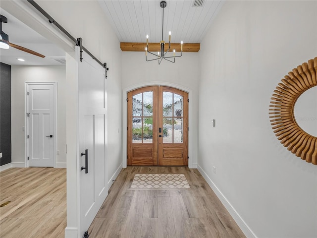 foyer with french doors, wooden ceiling, beamed ceiling, light hardwood / wood-style floors, and ceiling fan with notable chandelier