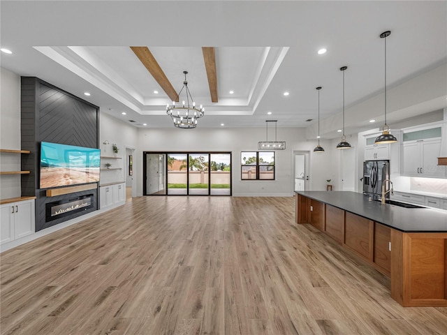 2728 Sunrise Landing Ln, Lakeland, FL 33812 - unfurnished living room featuring a fireplace, light wood finished floors, recessed lighting, a sink, and a raised ceiling