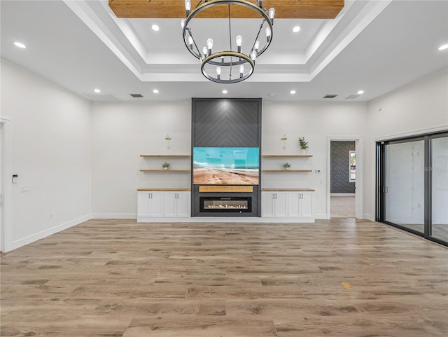 2728 Sunrise Landing Ln, Lakeland, FL 33812 - unfurnished living room with a raised ceiling, a chandelier, light wood-style flooring, recessed lighting, and baseboards