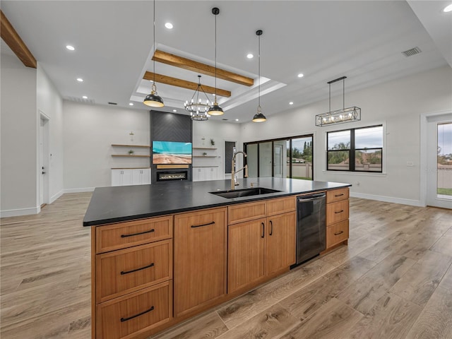 kitchen with sink, black dishwasher, light hardwood / wood-style flooring, a large island with sink, and pendant lighting